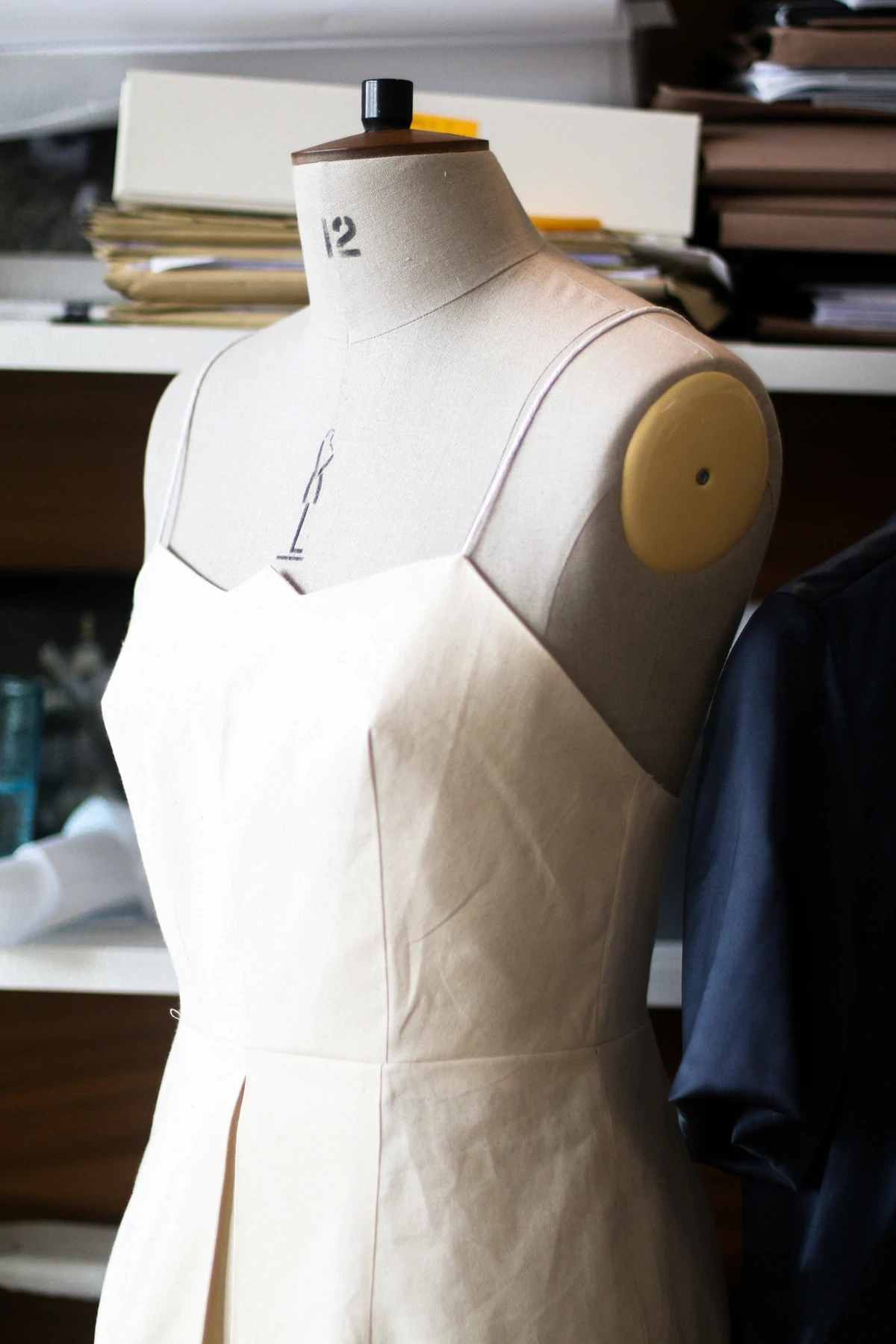 A bust where a sample of a white dress is being finished by Hanna Fiedler 
