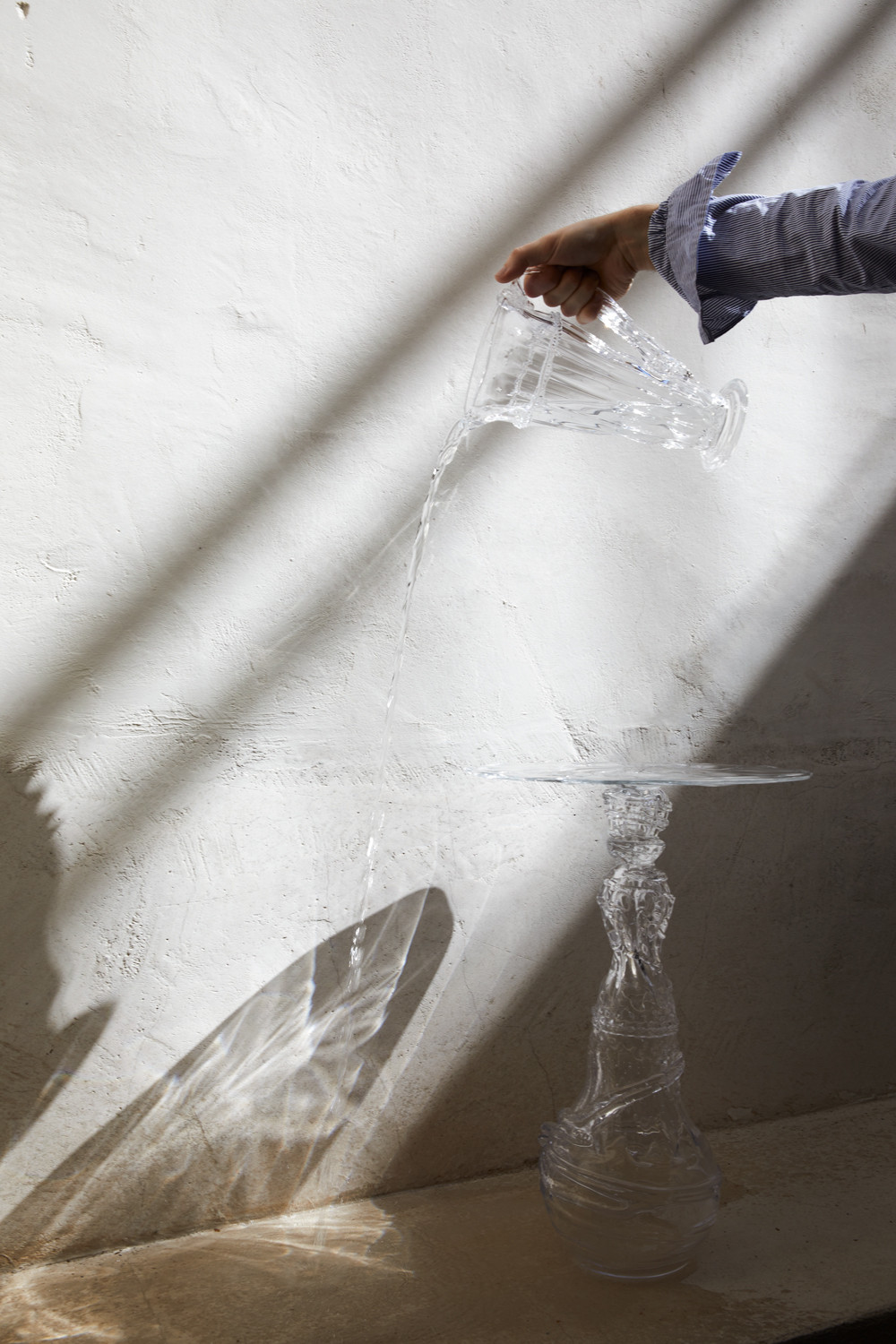 a picture of a hand pouring water from a beautiful tumbler 