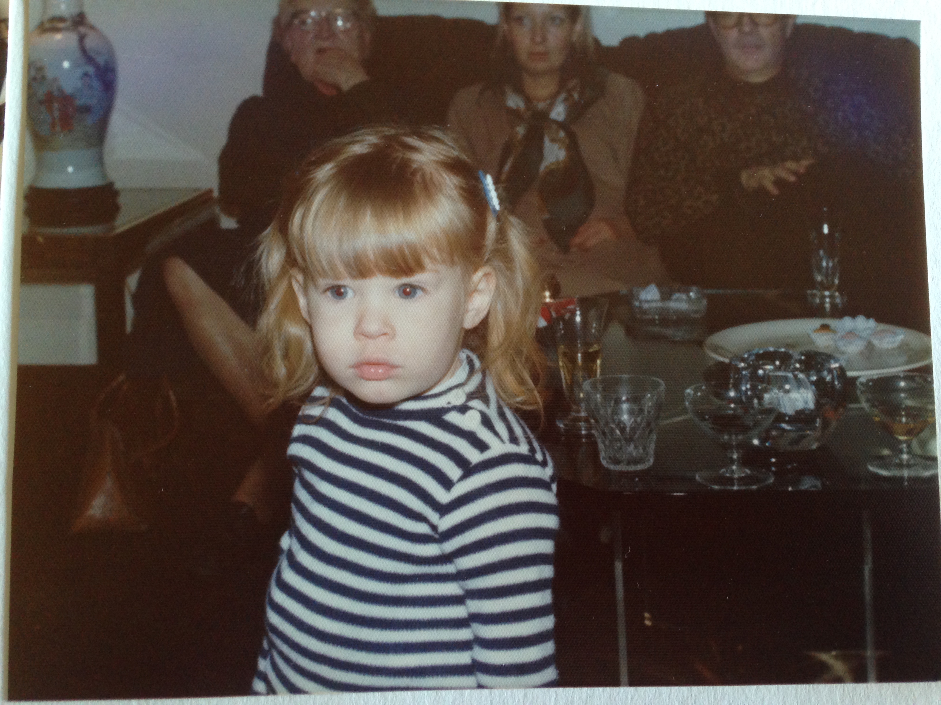 A picture of Anne Muhlethaler as a toddler in front of her mother and uncles. 